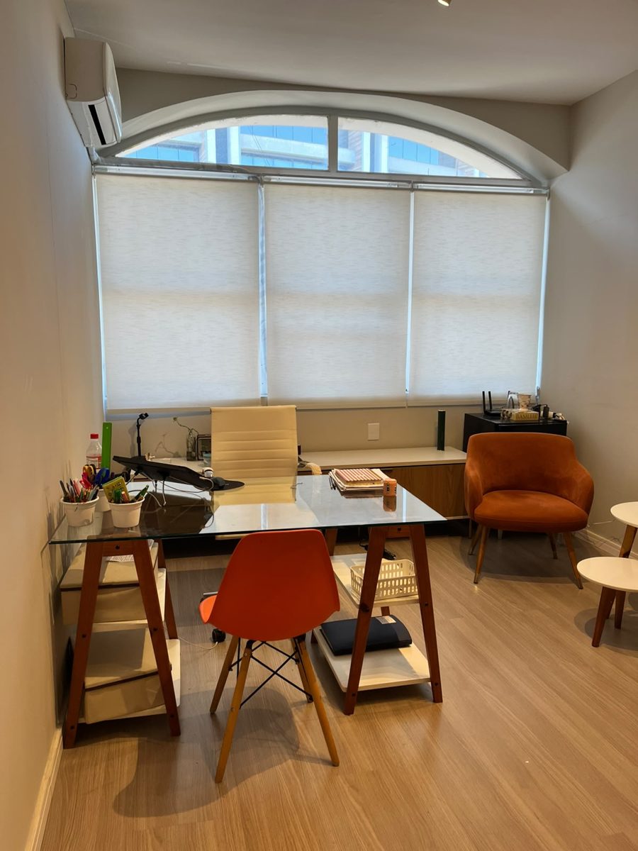 Sala de atendimento com mesa e janela em arco