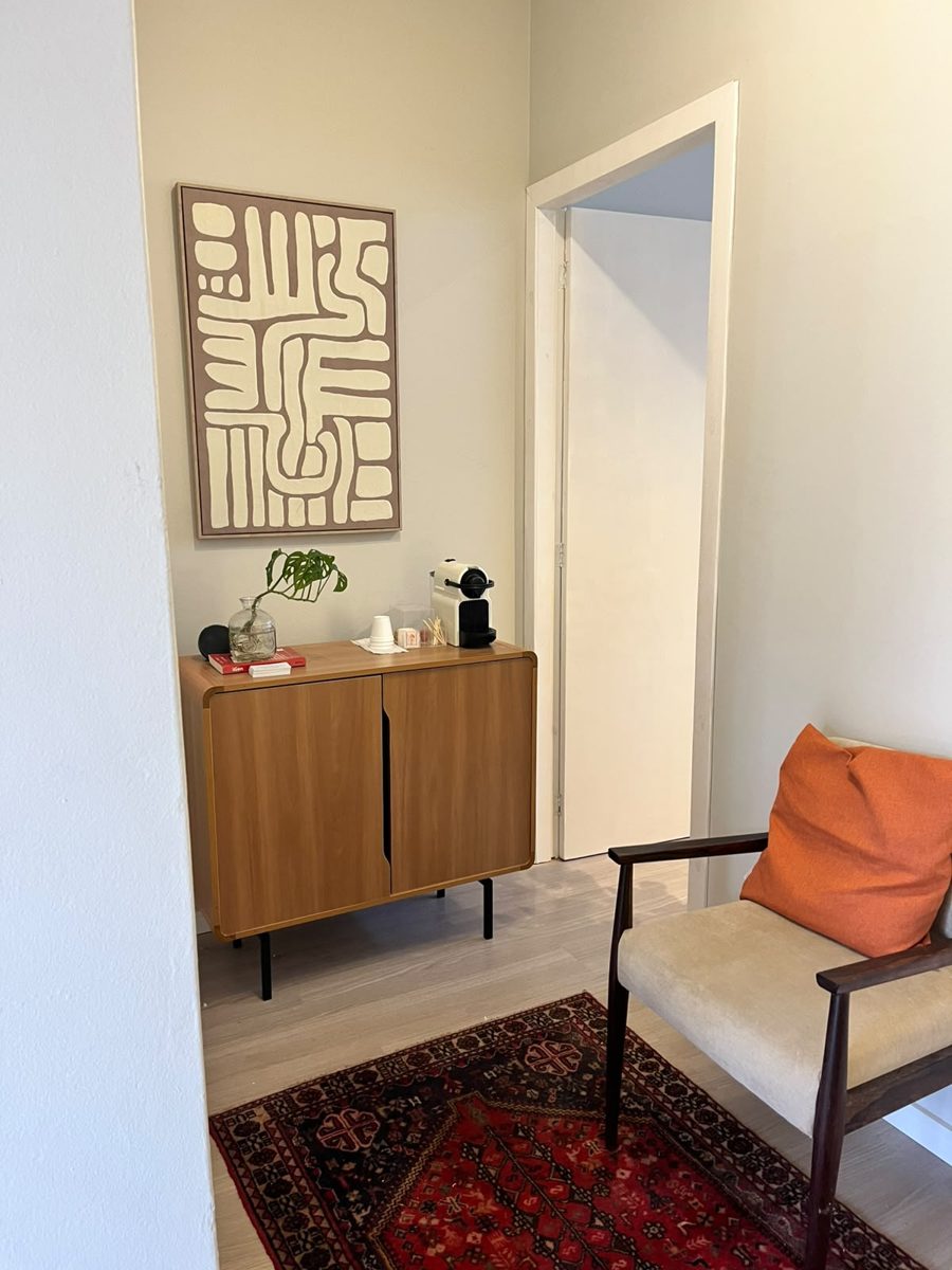 Recepção do consultório com aparador e poltrona